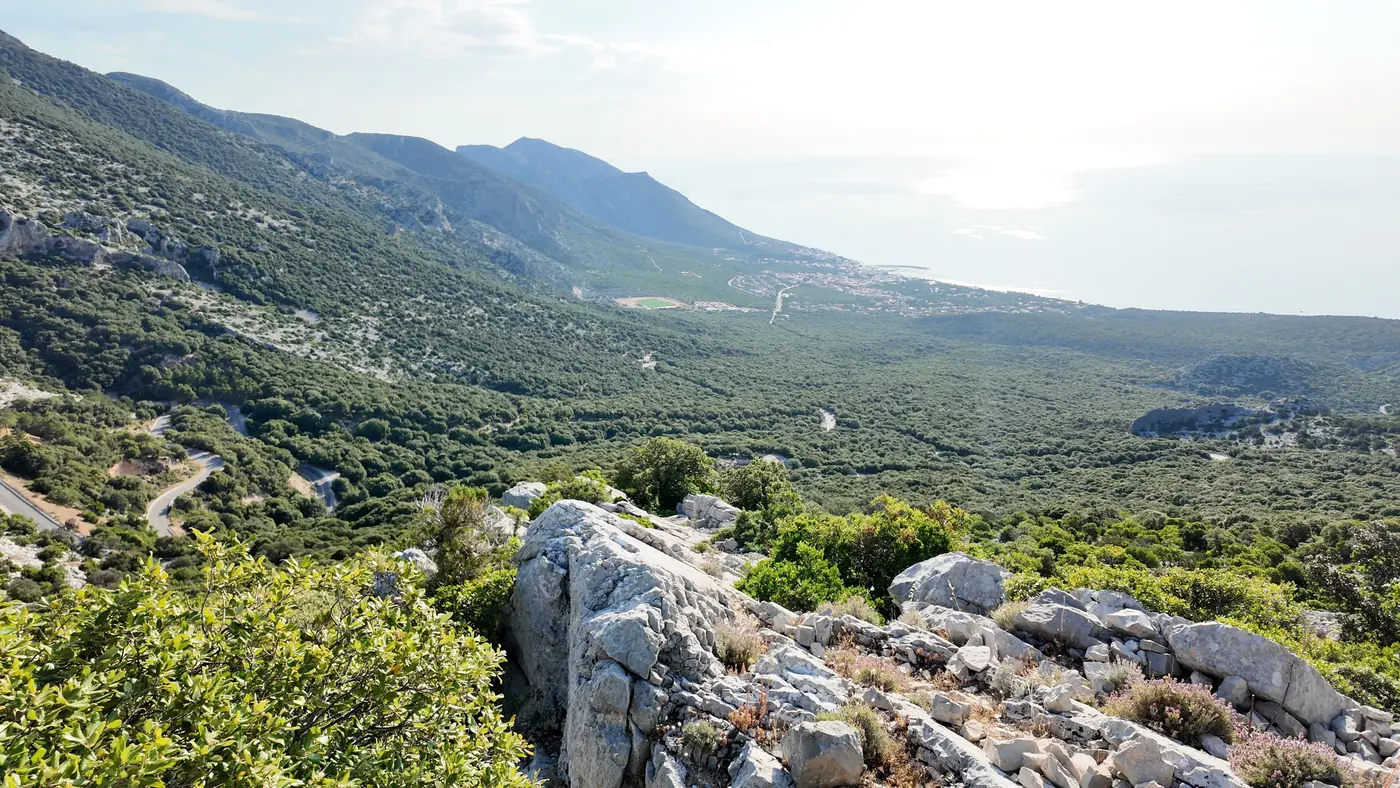 The view from a morning hike above Cala Gonone, over a wide green valley to the mountains