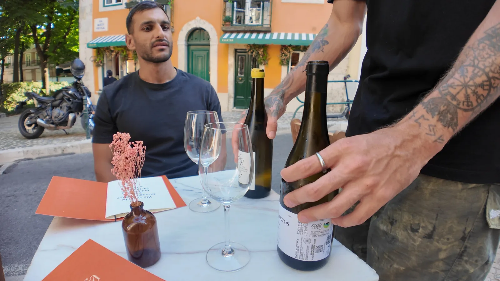 Tijs at an outdoor table at Magnolia on Praça das Flores while wine is poured